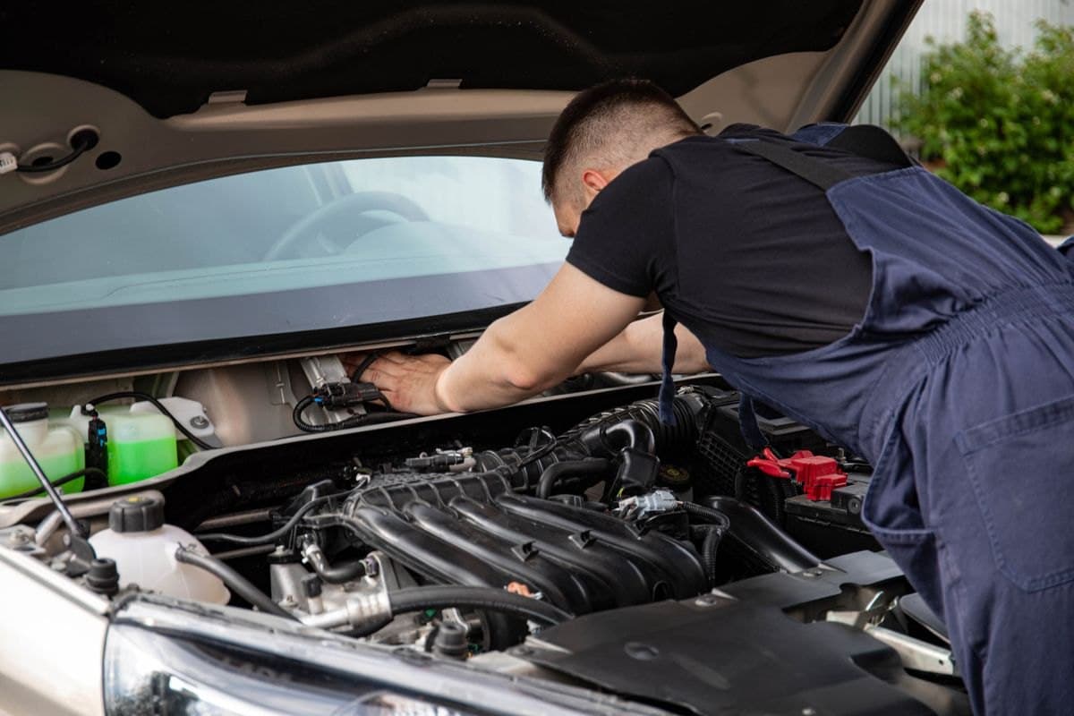 A technician servicing a vehicle engine